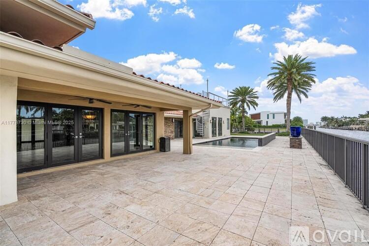 A sunny day at the outdoor patio of a building with a palm tree in the background.