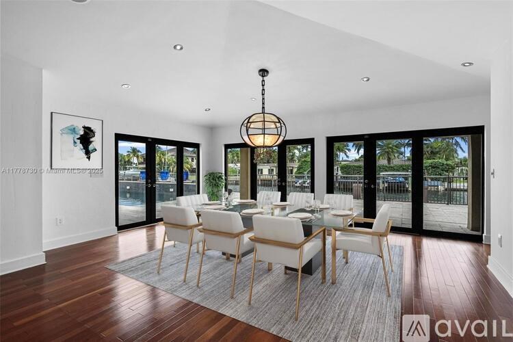 A modern dining room with a wooden floor and a chandelier hanging from the ceiling.