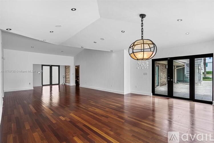 A room with wooden floors and a hanging light fixture.