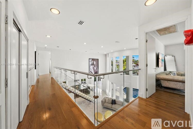 A long hallway with a glass railing and a wooden floor.