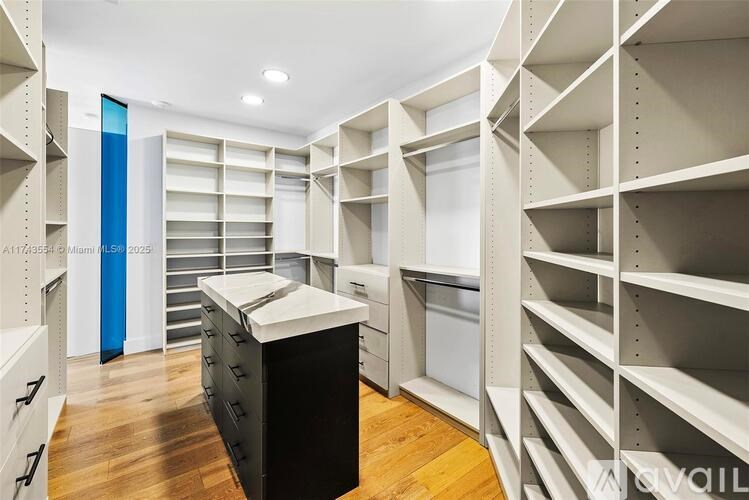 A kitchen with a black counter and white cabinets.