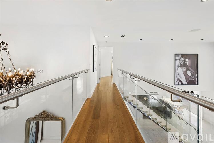 A long hallway with a glass railing and a wooden floor.
