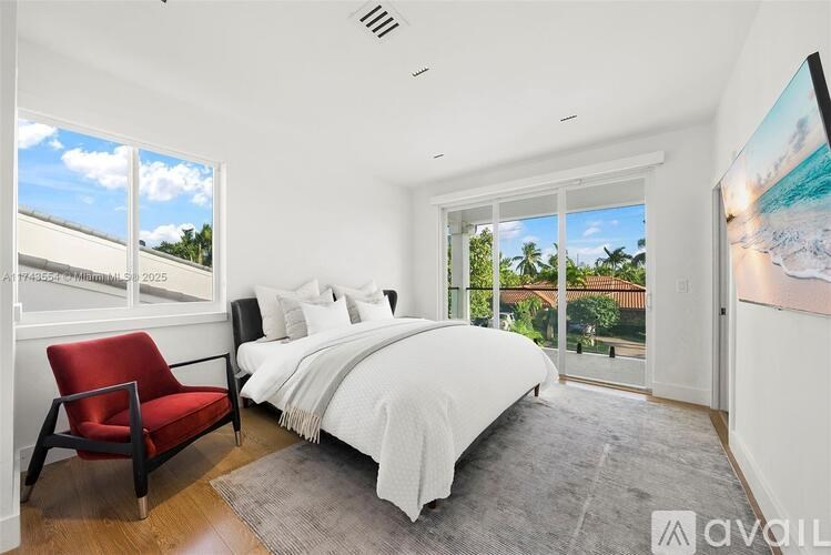 A bedroom with a large bed and a red chair.