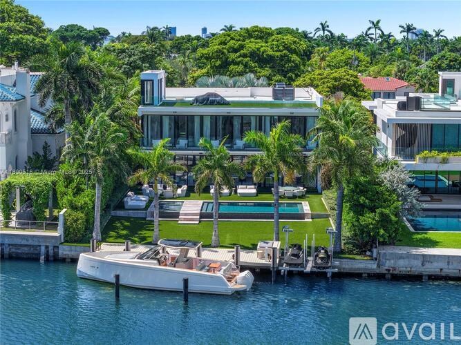 A modern house with a boat docked in front.