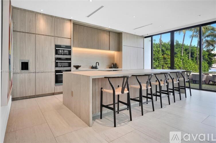 A modern kitchen with a long island and bar stools.