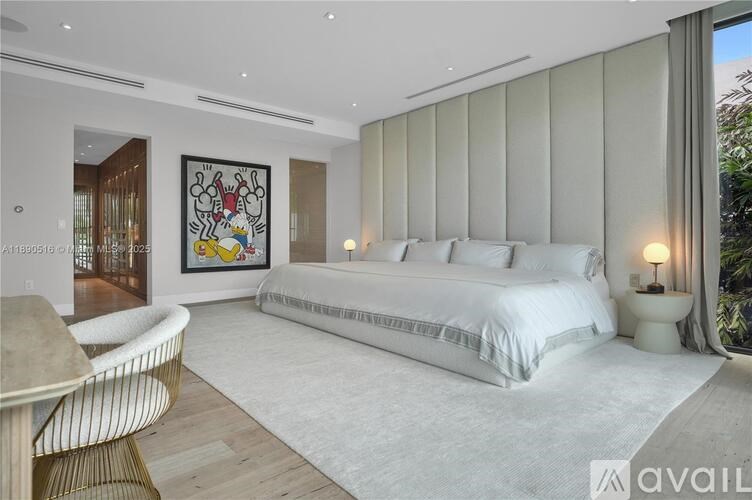 A bedroom with a large bed and a painting on the wall.