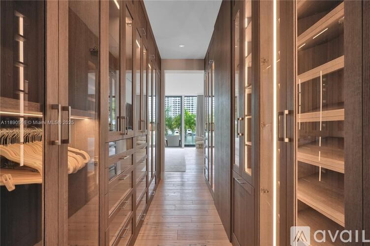 A long hallway with wooden doors and shelves on the side.