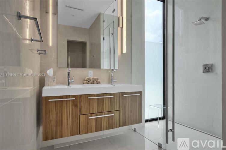 A modern bathroom with a wooden vanity and a glass shower area.