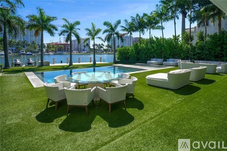 A pool surrounded by chairs and palm trees.