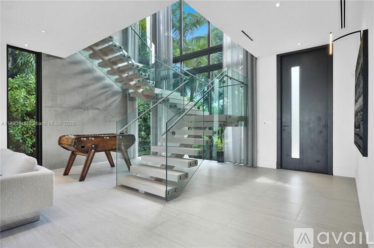 A modern interior with a glass staircase and a wooden bench.