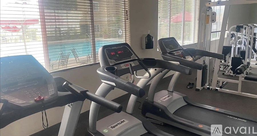 A treadmill in a gym with a digital display showing the time.