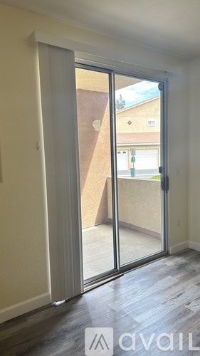 A room with a sliding glass door leading to a balcony.