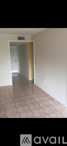 A hallway with tiled flooring and white walls.