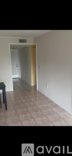 A hallway with a tiled floor and a door on the right.