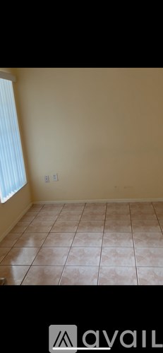 A room with beige walls and tiled flooring.