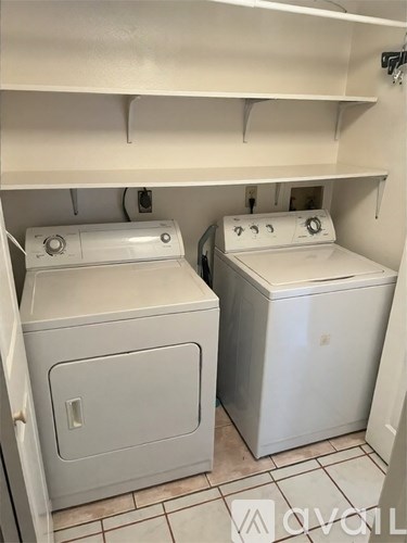A white washing machine and dryer in a small laundry room.