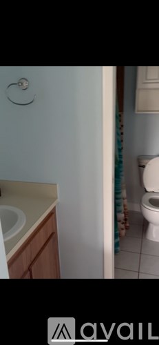 A bathroom with a toilet, sink, and a towel rack.