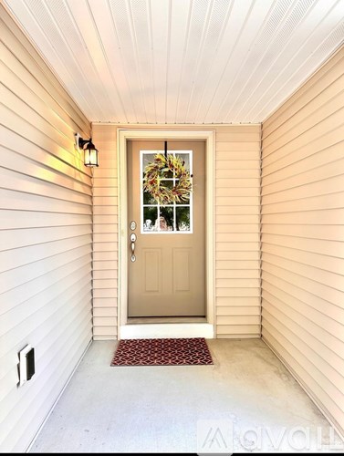 A door with a wreath on it is in a hallway.
