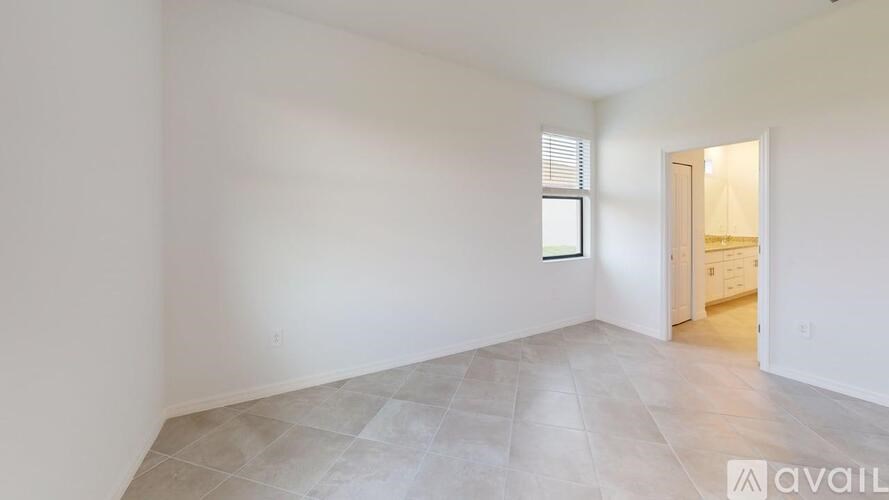 A room with a tiled floor and a door leading to another room.
