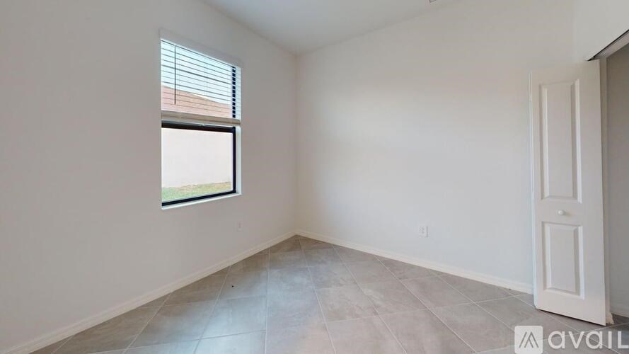 A room with a window and a door is available for rent.