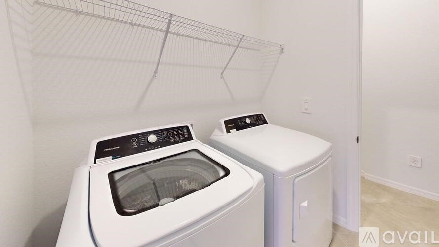 A white dryer and washing machine in a laundry room.