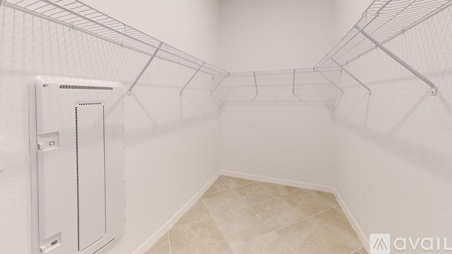 A white walk-in closet with shelving and a tiled floor.