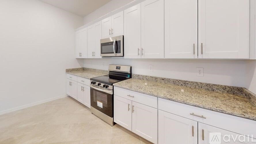 A kitchen with white cabinets and a granite countertop.