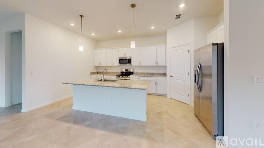 A kitchen with a white island and stainless steel appliances.