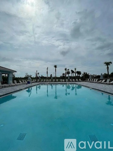 A large outdoor swimming pool with a cloudy sky in the background.