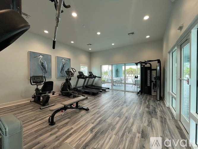 A well-lit gym with a variety of equipment including treadmills, stationary bikes, and weight machines.