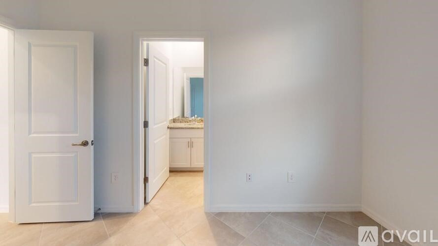 A room with a door and a wall with a few switches and sockets.