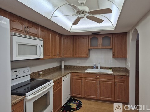 A kitchen with wooden cabinets and white appliances.