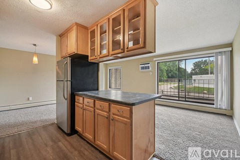 A kitchen with wooden cabinets and a black fridge.
