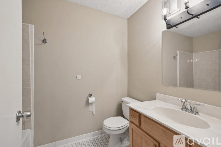 A bathroom with a toilet, sink, and shower.