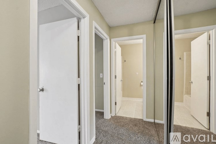 A hallway with white doors and a carpeted floor.