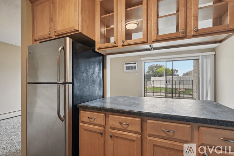 A kitchen with wooden cabinets and a black countertop.