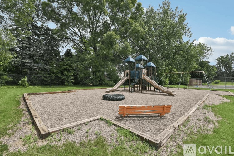 A playground with a slide, swings, and a sandbox.