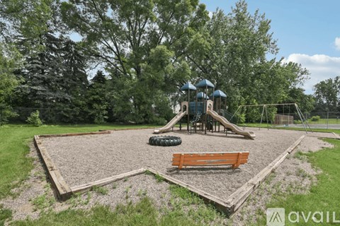 A playground with a slide, swings, and a sandbox.