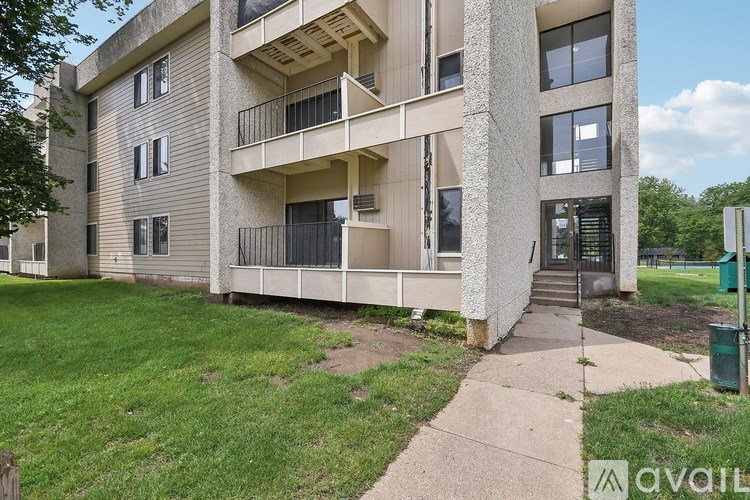 Apartment building with a green trash can in front.
