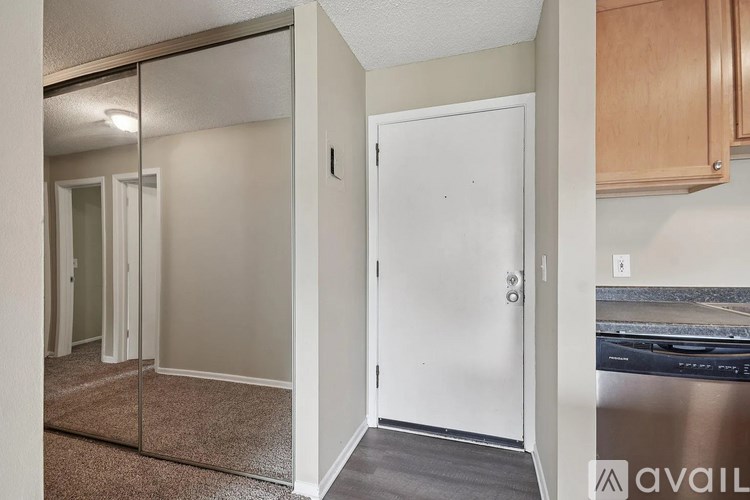 A room with a white door and a mirrored wall.