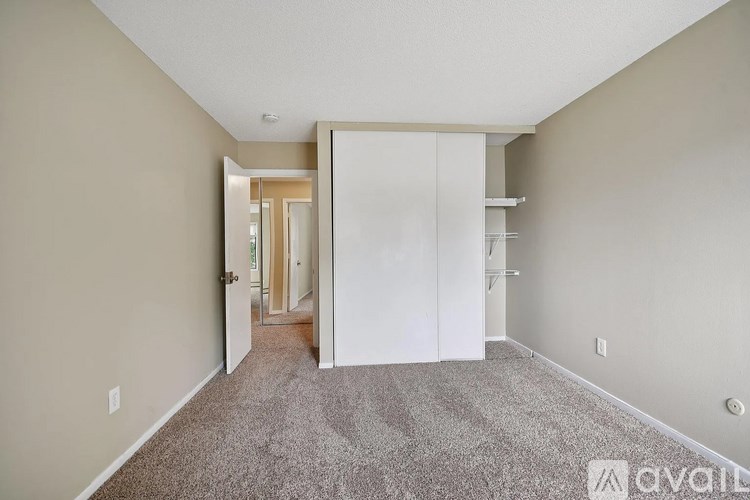 A room with a white door and a carpeted floor.