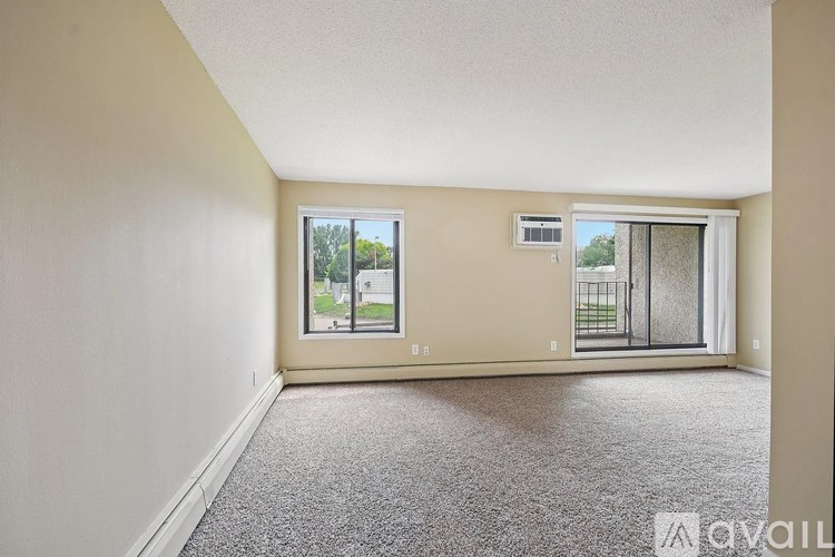 A room with a carpeted floor and a window overlooking a balcony.