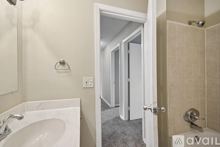 A bathroom with a sink, mirror, and shower.