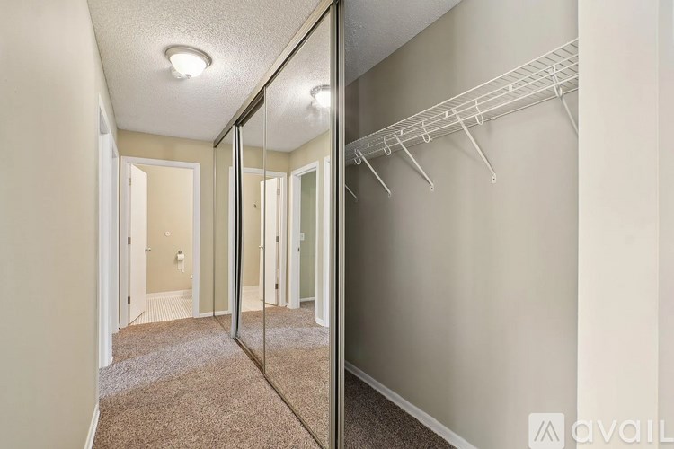 A hallway with a mirrored wall and a carpeted floor.