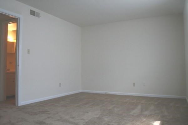 an empty living room with white walls and a door
