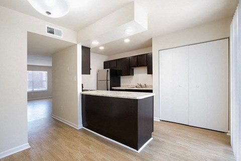 A kitchen with white cabinets and a black island.