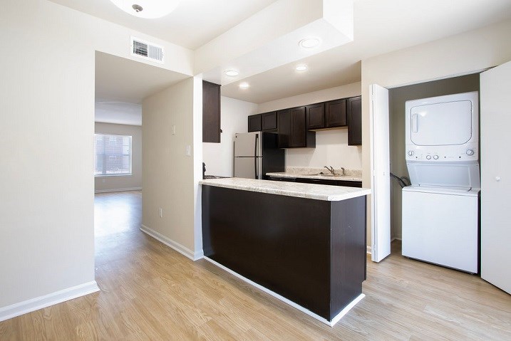 A kitchen with a black counter top and white appliances.