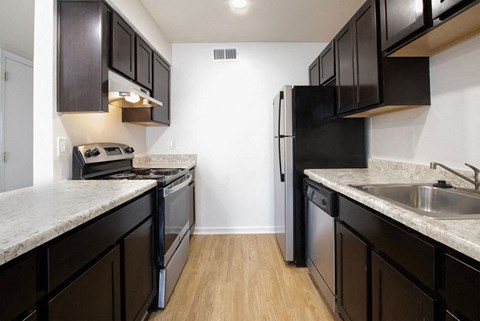 A kitchen with black cabinets and a granite counter top.
