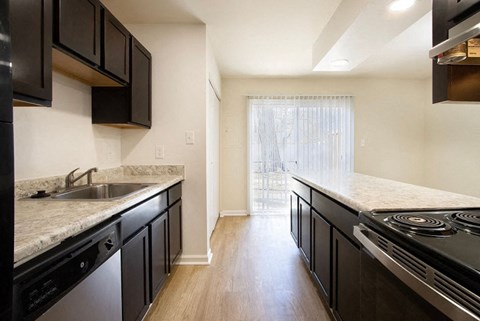 A kitchen with black cabinets and a marble countertop.