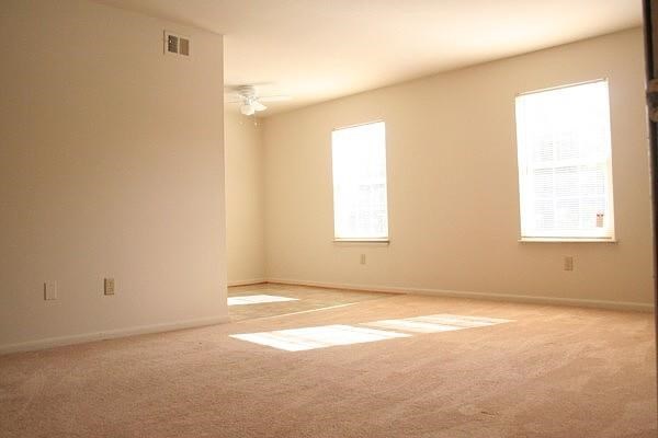 an empty living room with two windows in it